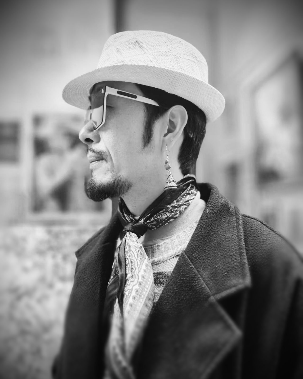 Lin Feng, oil painter based in Shenzhen, wearing a white hat and patterned scarf in his studio